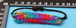 Multi-coloured adjustable bracelet. Tapestry crochet and black chord, adjustable length 16 - 21 cm