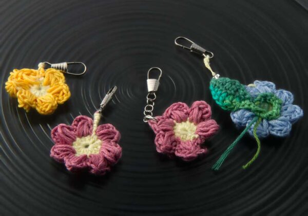 4 daisy charms, yellow, pink, pink with pearl toned bead, and powder blue with leaf and green bead in centre and clear bead chain