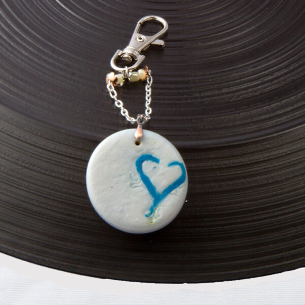 Blue Heart inlaid in pearl polymer clay circle. Handbag charm
